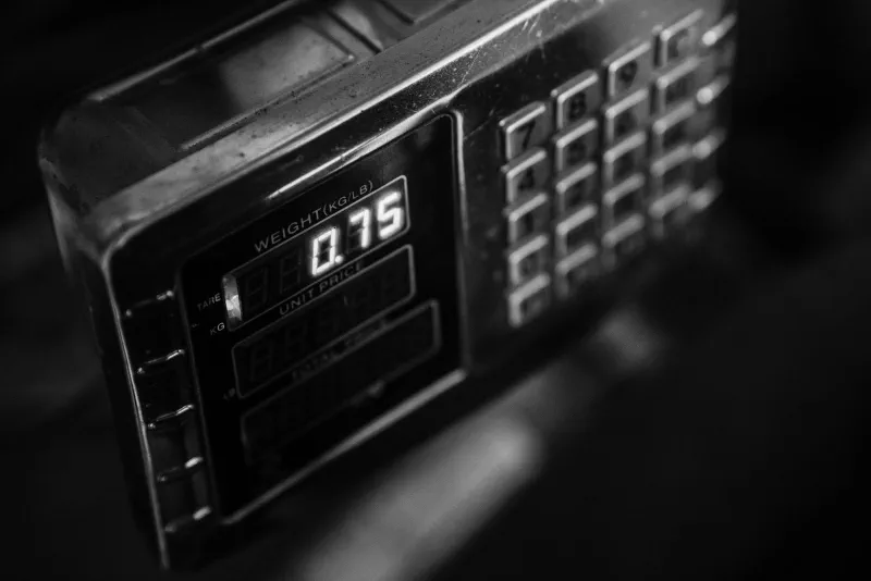 Close up of a digital scale display reading weight, unit price, and total next to a numeric keypad