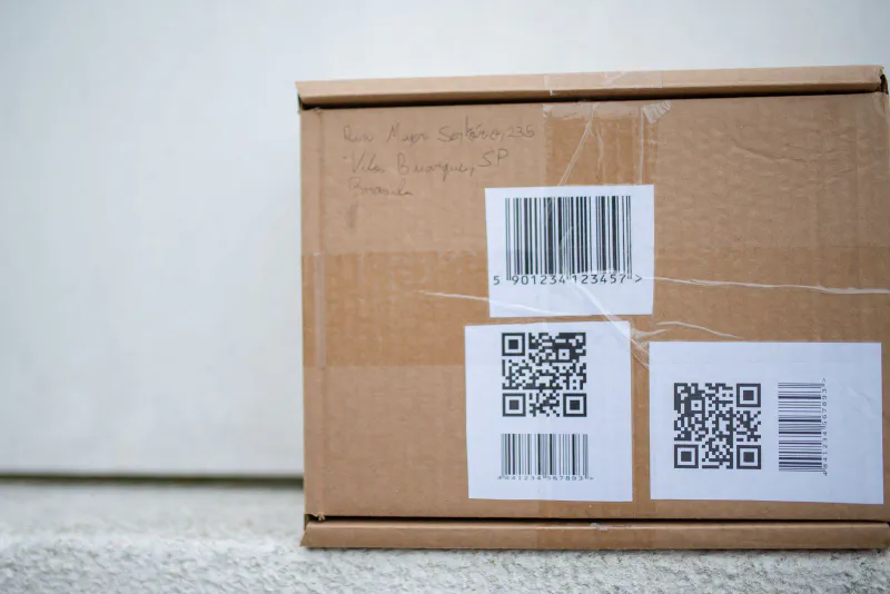 Close-up of a cardboard box with barcode and QR code shipping labels